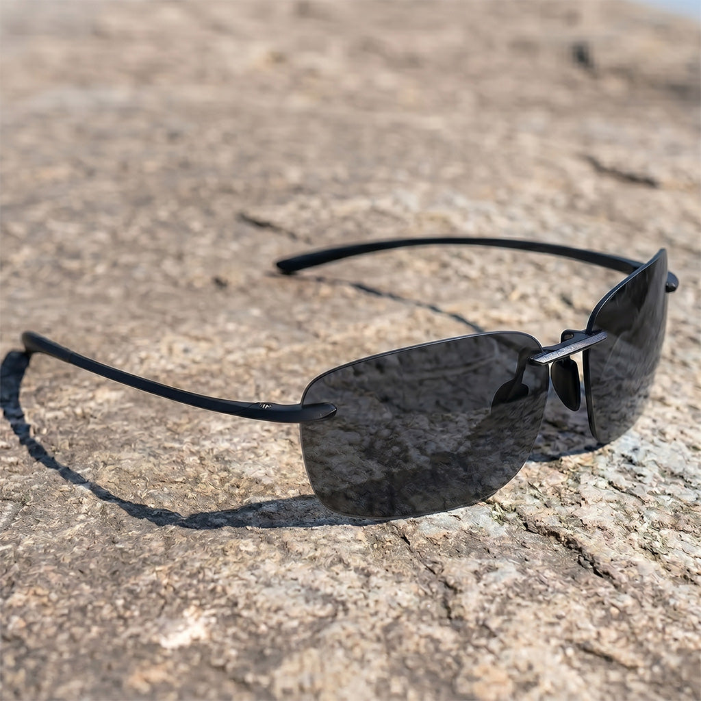 Black sunglasses on a textured stone surface