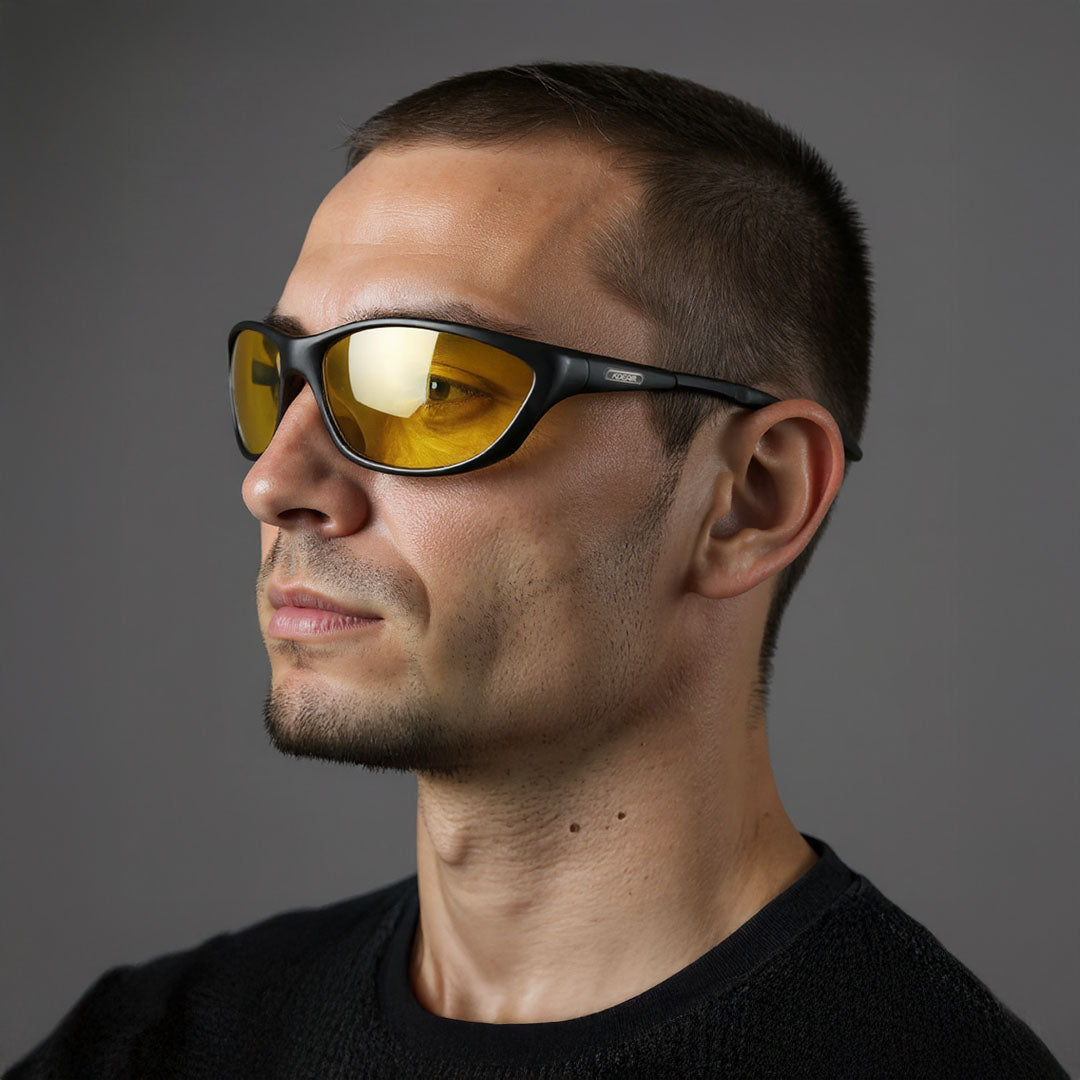 Man wearing yellow-tinted sunglasses against a gray background